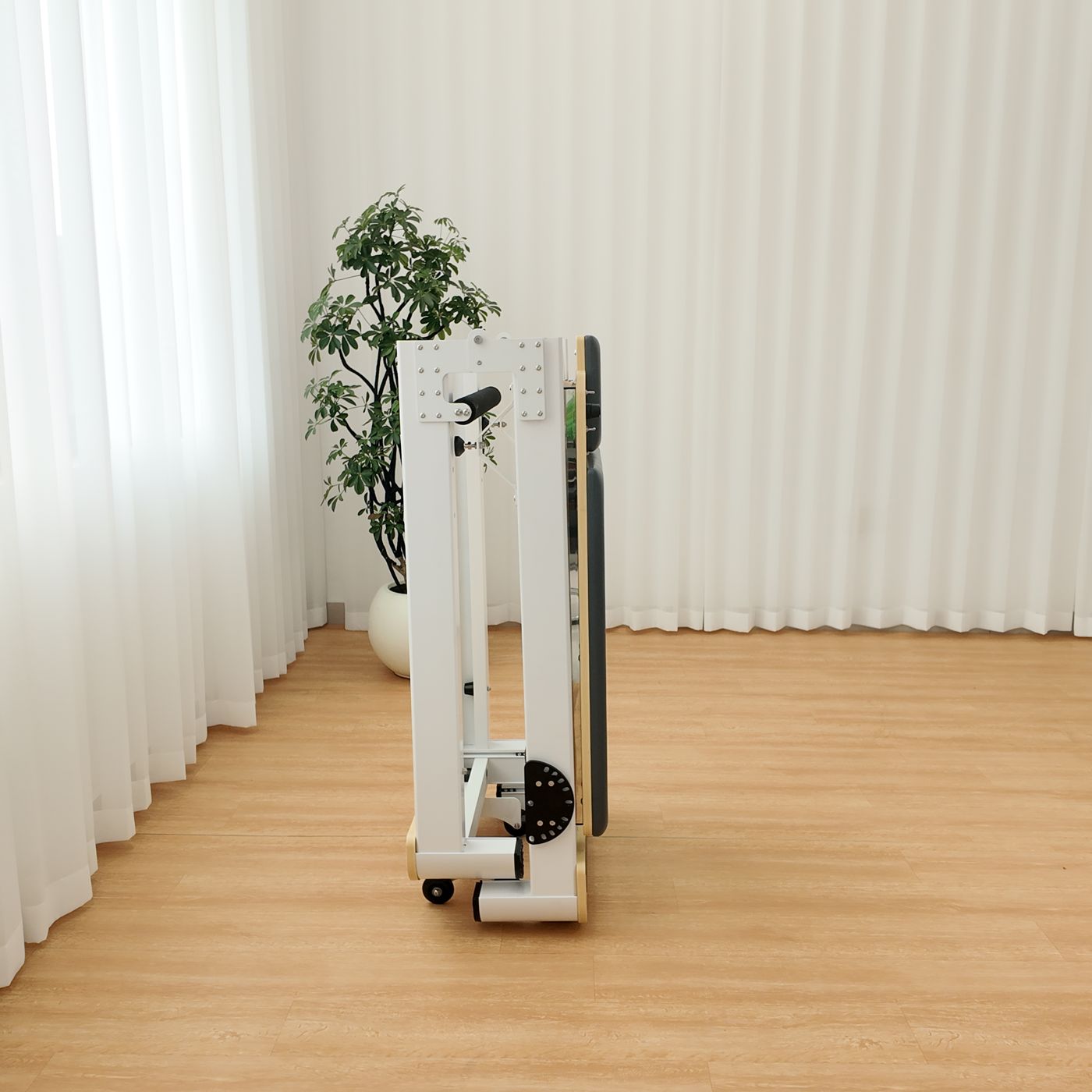 The same reformer folded and standing upright, side view.